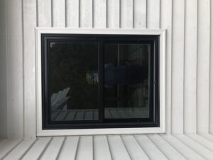 Black vinyl double-hung window replacement on white residential siding in Bonney Lake